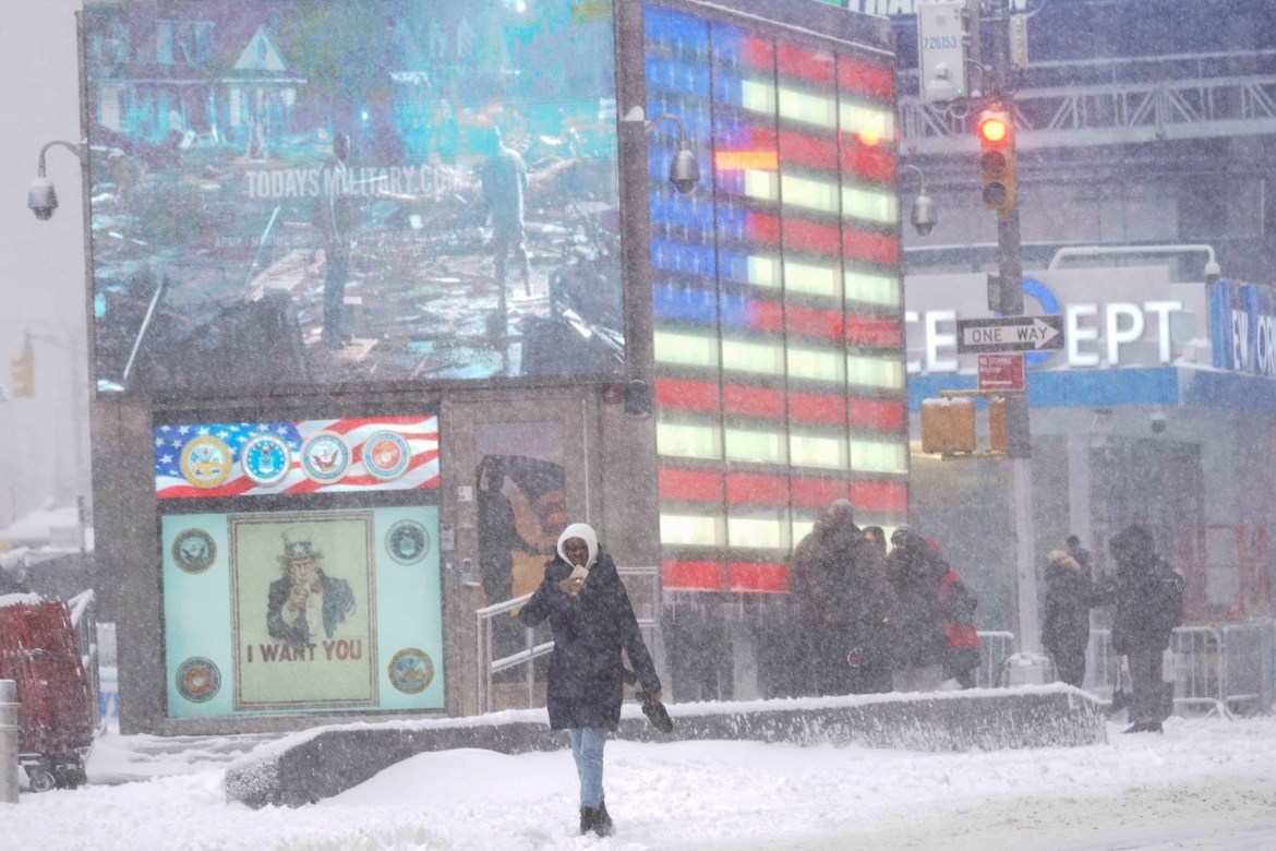 Visitors make their way through New York's Times Square during a snow storm,
