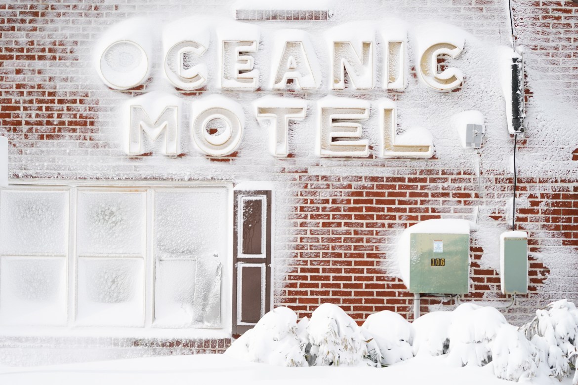 Signage outside of a motel is covered in snow, Saturday, Jan. 29, 2022, in Ocean City,