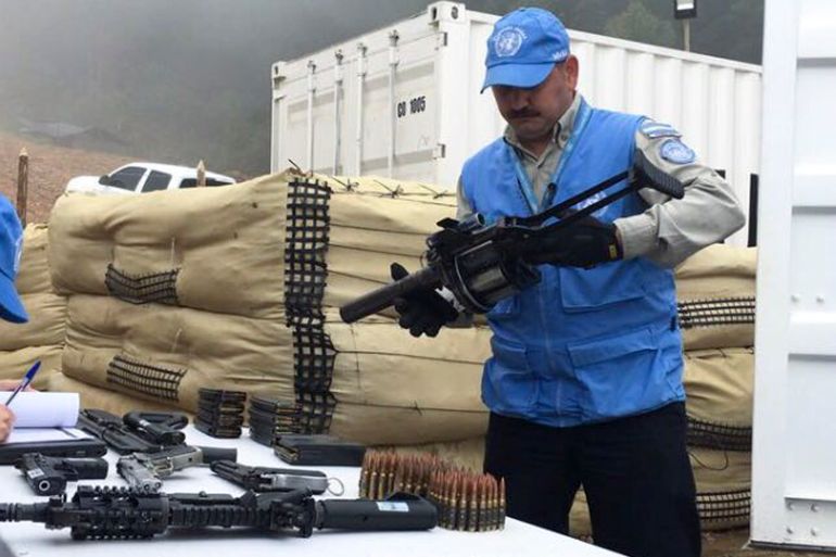 A UN worker holds a weapon handed over from former FARC rebels following 2016 peace agreement.