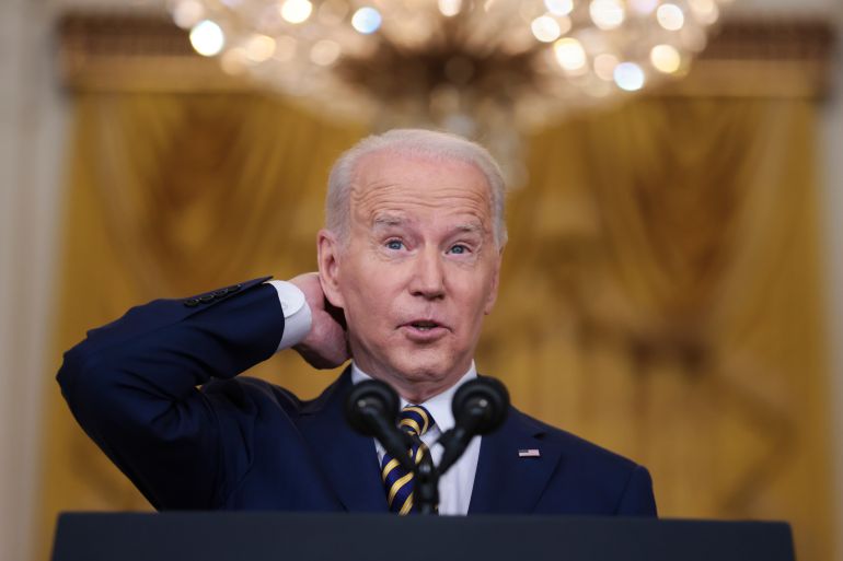 President Joe Biden gestures as he talks to the media in the East Room of the White House