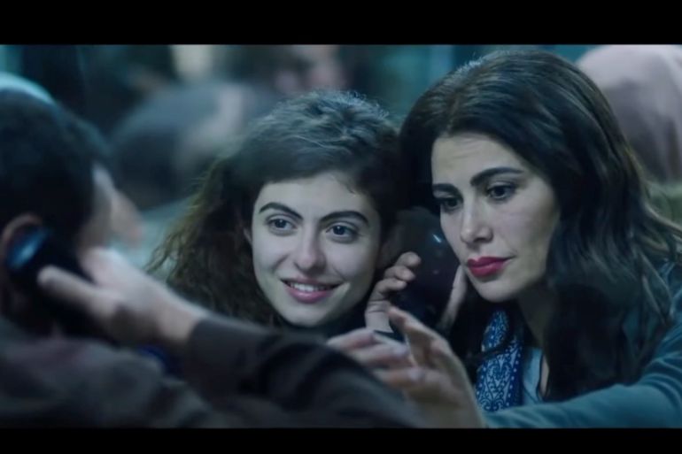 In a scene from the film Amira, two women seen talking to an incarcerated man on the phone