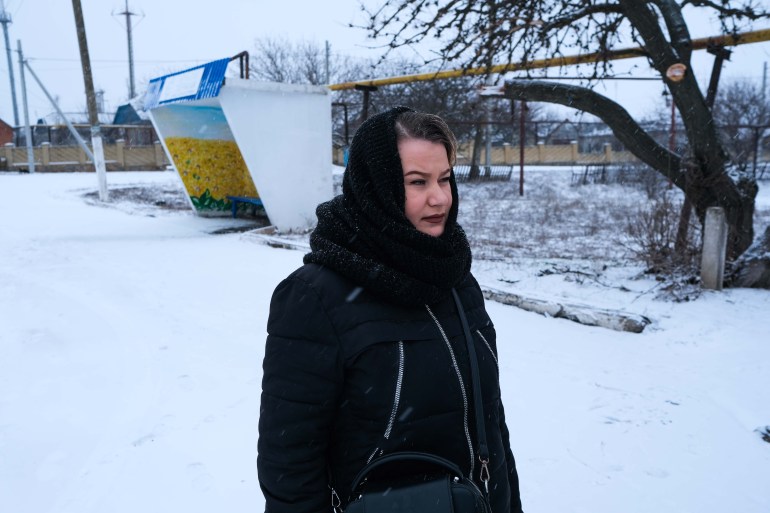 Natalia, a pensioner who lives on the river bank, walks in the snow.