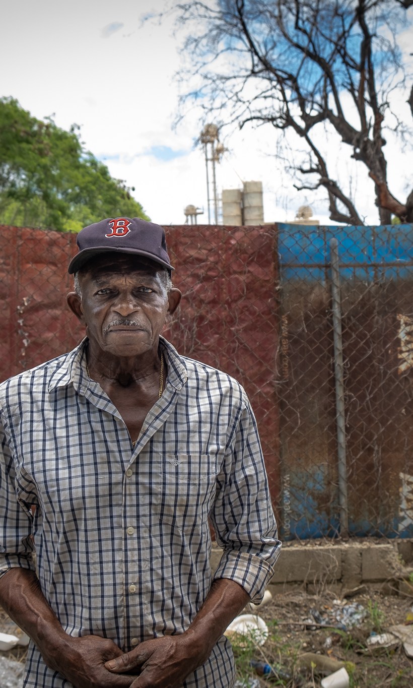 Ramon German, 81, stands in front of the area used for dumping rotting fruit