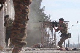 A Syrian Democratic Forces soldier points a gun outside a prison while in clash with the ISIL fighters in Hasakeh