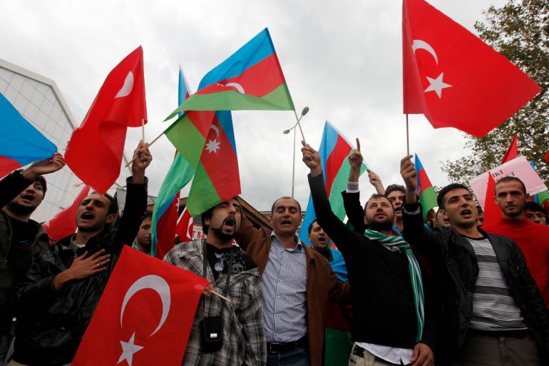 Demonstrators waving Turkey's and Azerbaijan's national flags protest aganist the agreement signed between Turkey and Armenia