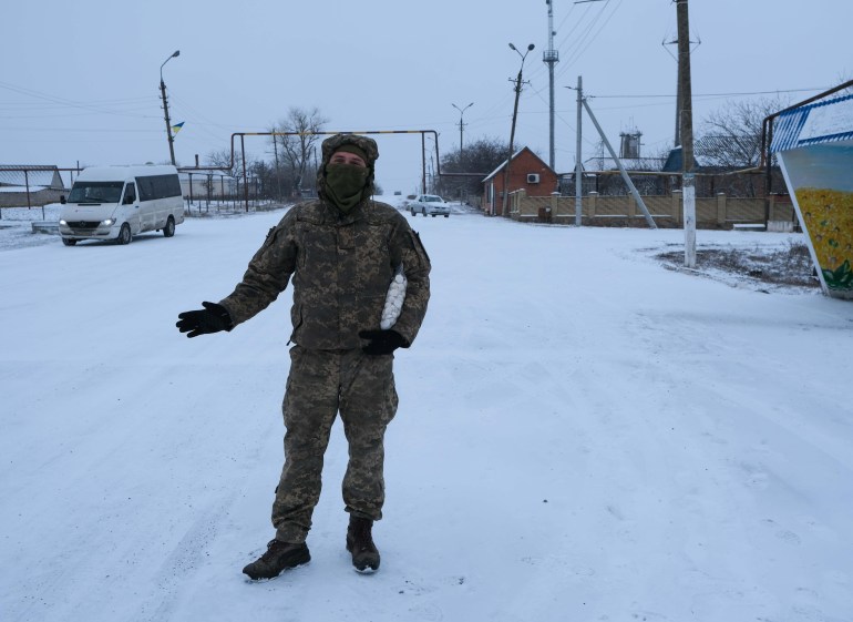 A Ukrainian soldier walking in the snow.