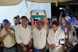Sergio Garrido holds the flag of Barinas after winning the gubernatorial election.