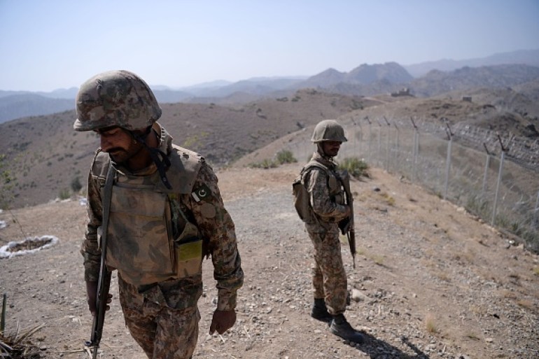 Pakistani soldiers patrol next to a border fencing in Pakistan's North Waziristan.