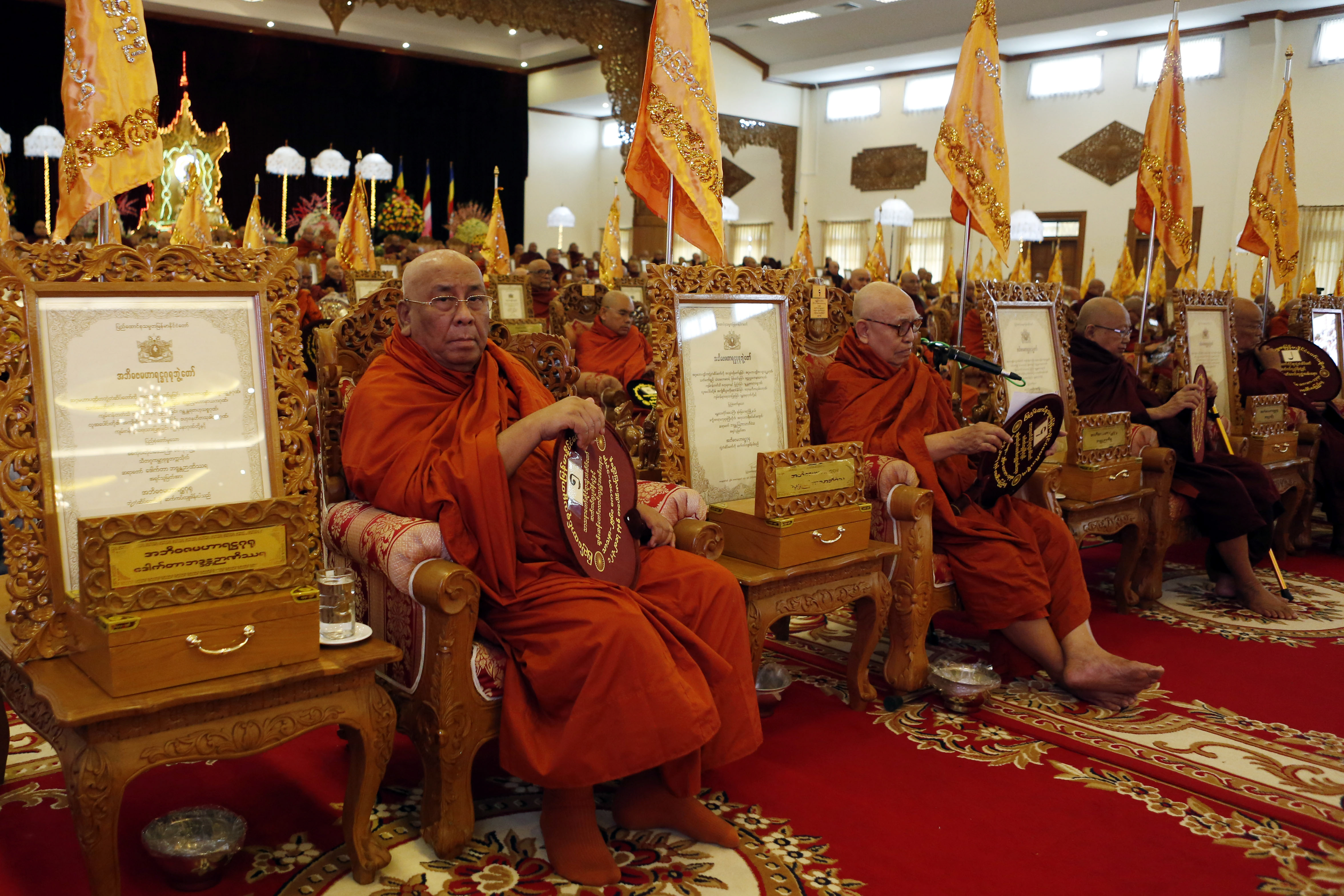 Prominent monk Sitagu Sayadaw in traditional saffron robes sits in a carved wooden seat at a lavish ceremony in Naypyidaw