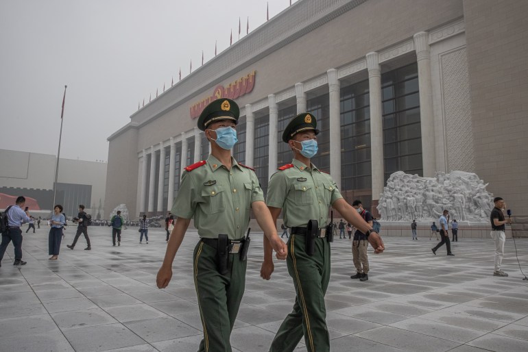 Chinese paramilitary police in summer unoforms march outside a new museum to the Chinese Commuist Party