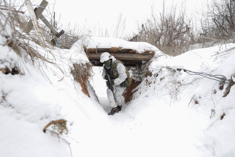 Ukrainian servicemen check the situation at the positions on a front line near the Avdiivka village