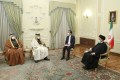 Iranian president Ebrahim Raisi (R) is seen talking to Qatar's Deputy Prime Minister and Foreign Minister Mohammed bin Abdulrahman Al-Thani in a room