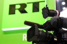 RT broadcaster's logo with a camera in the foreground