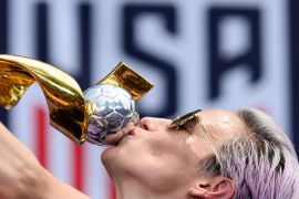 Megan Rapinoe kisses a trophy