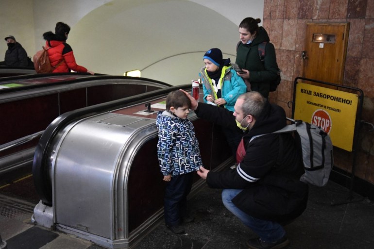 Alexander (R), reassures his son as the family takes refuge in a metro station in Kyiv