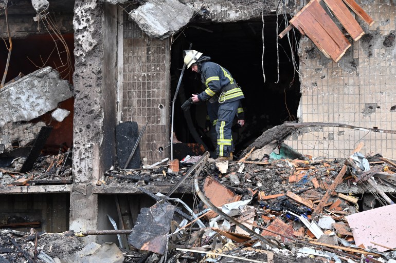 Firefighters are seen working at a damaged residential building in a suburb of the Ukrainian capital Kyiv