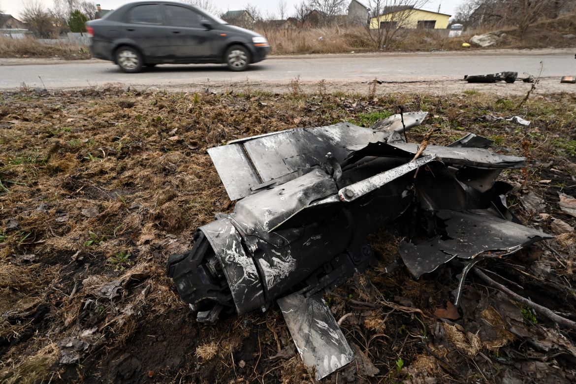 A car drives past the remains of a rocket in a residential area in the Ukrainian capital of Kyiv