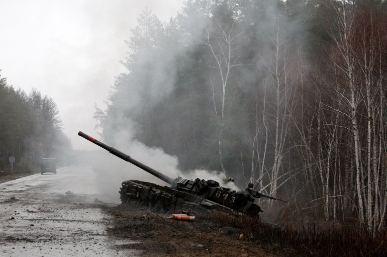 Smoke rises from a Russian tank destroyed in Ukraine