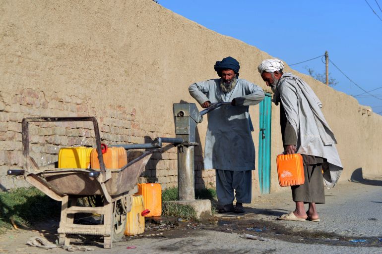 Men collect water from a well in Kandahar.