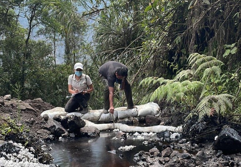 men in the Amazon region of Ecuador examine an oil spill