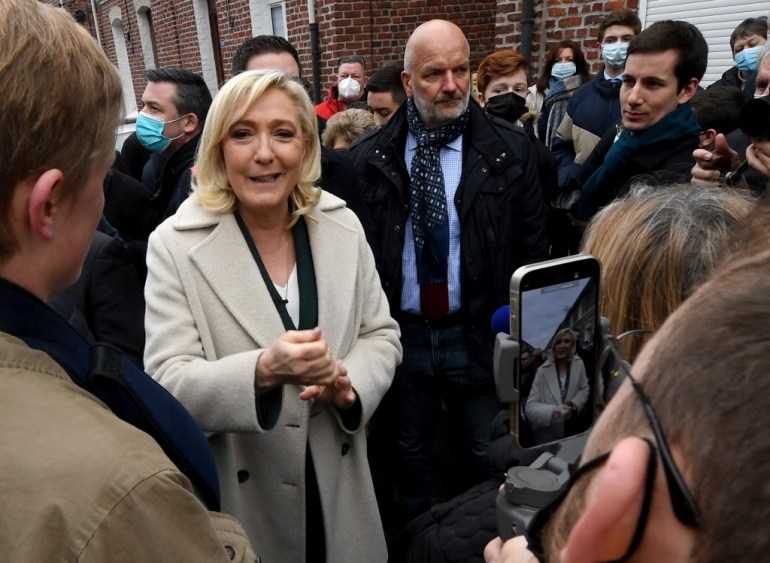 Marine Le Pen (L) meets residents during a campaign visit in Bruay-la-Buissière