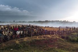 Dozens of displaced people gather along the fence of the MONUSCO base (the United nations mission in DR Congo) in the Rhoo IDP camp