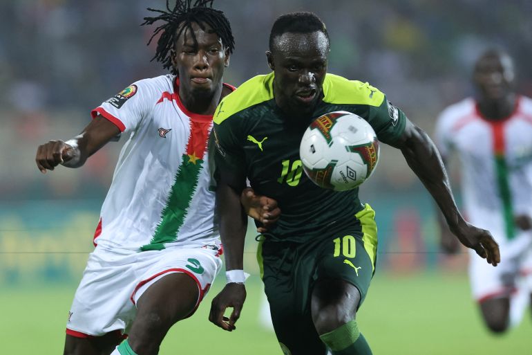 Burkina Faso's defender Issa Kabore, left, challenges Senegal's forward Sadio Mane.