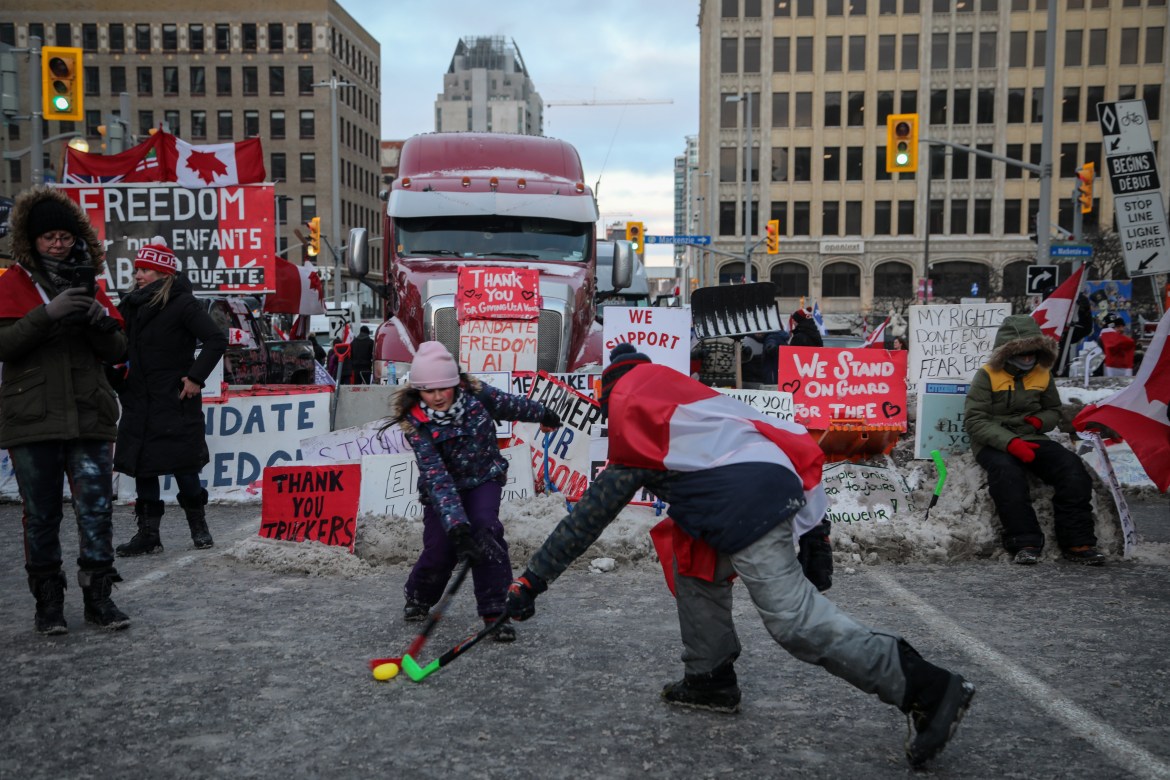 The children of demonstrators play a game of hockey on Rideau Street.