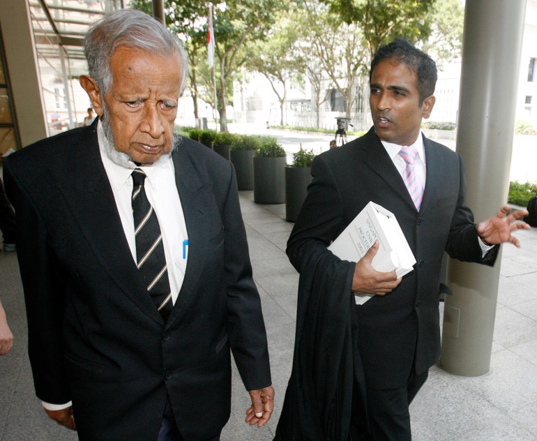 M Ravi and JB Jeyaretnam walk outside court in suit and lawyer's robes