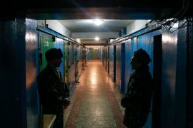 Donetsk remand prison employees stand guard along a corridor at a remand prison in Donetsk,