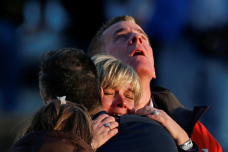 Lynn and Christopher McDonnell, the parents of seven-year-old Grace McDonnell, grieve near Sandy Hook Elementary after learning their daughter was one of 20 school children and six adults killed after a gunman opened fire inside the school in 2012.