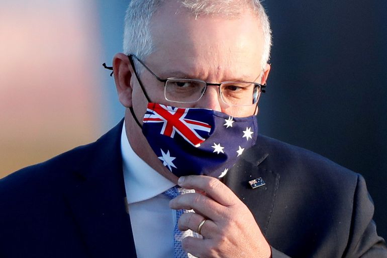 Former Australian Prime Minister Scott Morrison wearing a fask mask with his country's flag emblazoned on it.