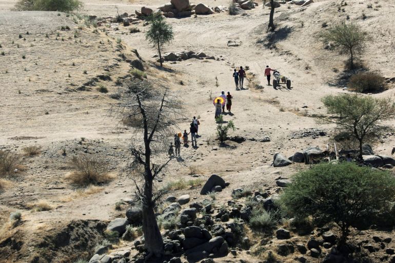 Ethiopians fleeing from the Tigray region walk towards a river to cross from Ethiopia to Sudan, near the Hamdeyat refugee transit camp, which houses refugees fleeing the fighting in the Tigray region, on the border in Sudan, December 1, 2020.