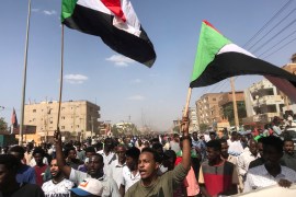 Protesters hold flags and chant slogans as they march against the Sudanese military government, in the streets of Khartoum. [File: Mohamed Nureldin/Reuters]