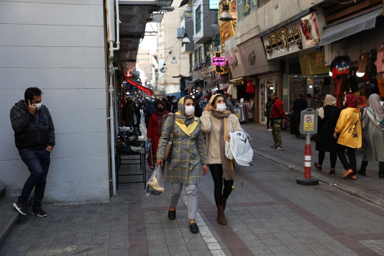 Iranians walk down a market street in Tehran, Iran 