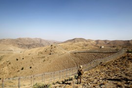 A soldier stands guard along the border fence outside the Kitton outpost on the border with Afghanistan in North Waziristan, Pakistan
