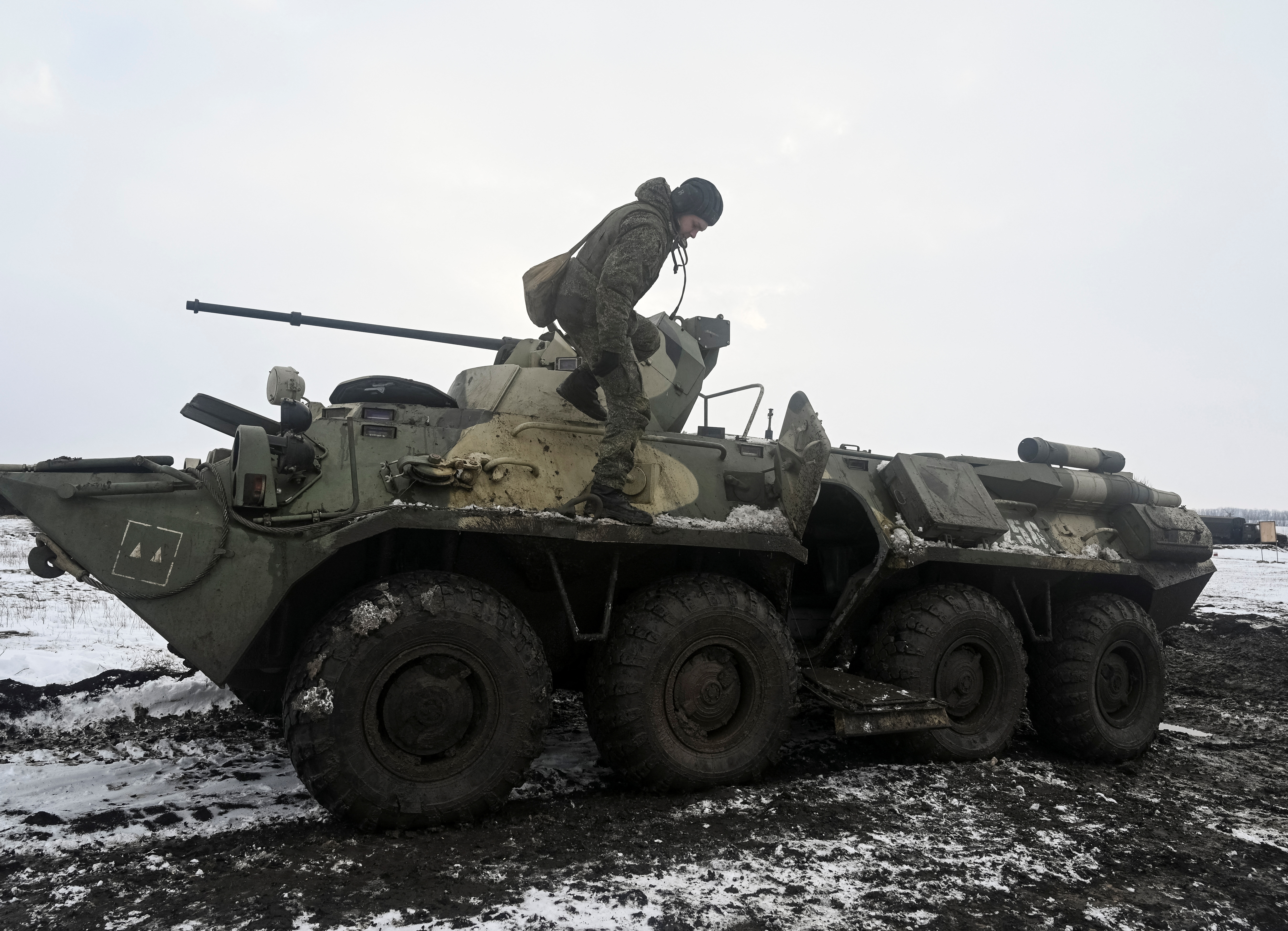 Un membro del servizio dell'esercito russo viene visto smontare da un veicolo corazzato durante le esercitazioni presso la gamma Kuzminsky nella regione meridionale di Rostov, Russia