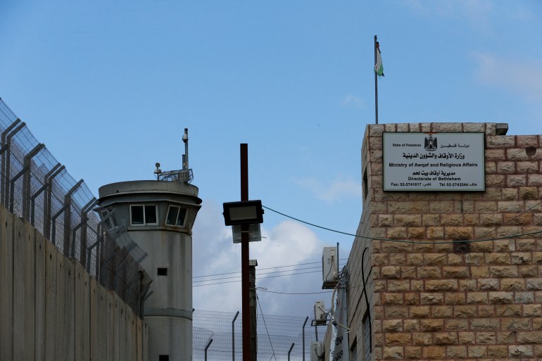 A Palestinian governmental office is seen next to an Israeli watch tower in a section of the Israeli barrier in Bethlehem