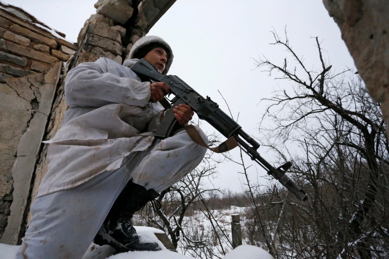 A fighter of the self-proclaimed Luhansk People's Republic holds a weapon at fighting positions on the line of separation from the Ukrainian armed forces in the village of Zholobok in Luhansk