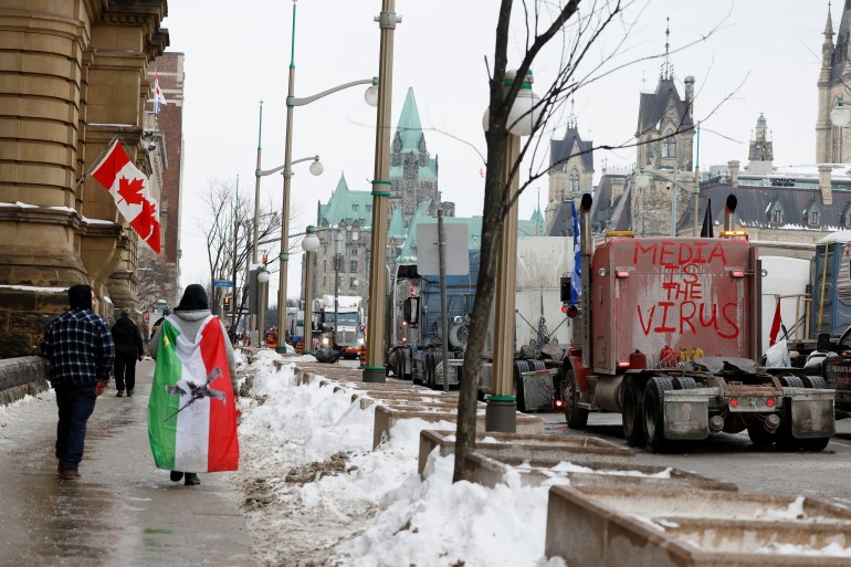 Protesters walk along a blockade by anti-vaccine truckers in Ottawa, Canada