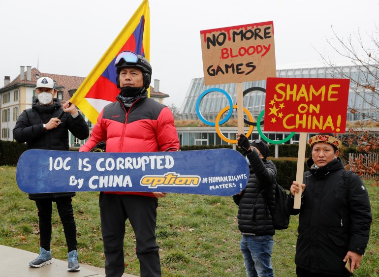 Migmar Dengo, a Tibetan who got Swiss asylum two decades ago, and other members of the Tibetan community living in Europe, pose with banners during a protest by the offices of the Chinese Olympic Committee (COC) in Lausanne, Switzerland.