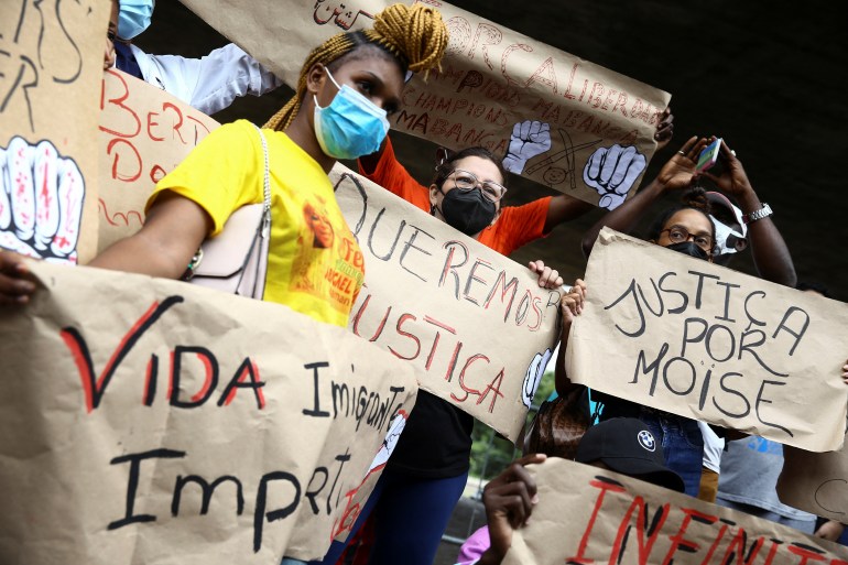 Demonstrators hold signs asking for justice after the death of Congolese refugee Moise Kabagambe, who was brutally killed in Rio de Janeiro, during a protest in Sao Paulo, Brazil