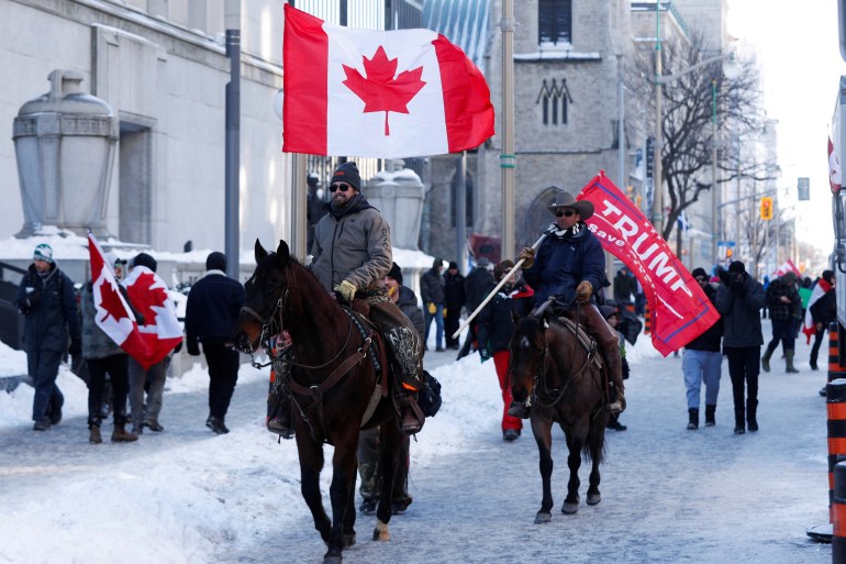 Protesters on horseback ride with flags as truckers and supporters continue to protest coronavirus disease (COVID-19) vaccine mandates, in Ottawa, Ontario, Canada, February 5, 2022.