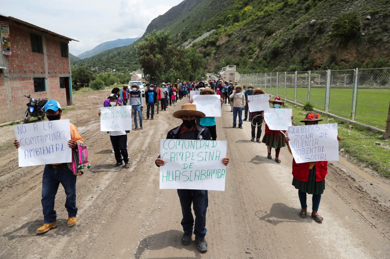 People march with signs reading 'No to environmental contamination' and 'Farming community of Huascabamba' in Sayhua, Peru