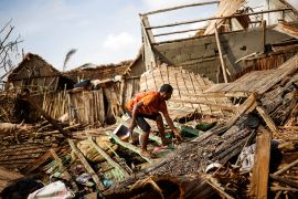 A man works on the destroyed house of Philibert Jean Claude Razananoro, in the aftermath of Cyclone Batsirai