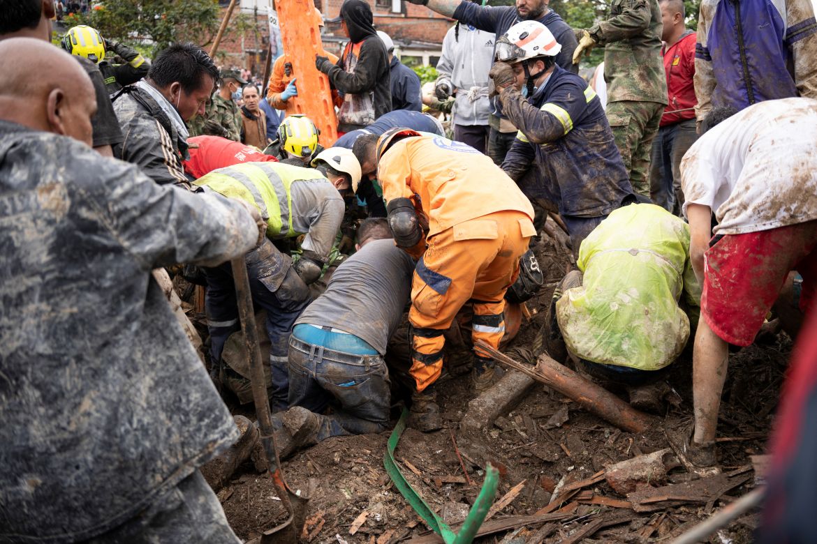 People remove debris following a landslide