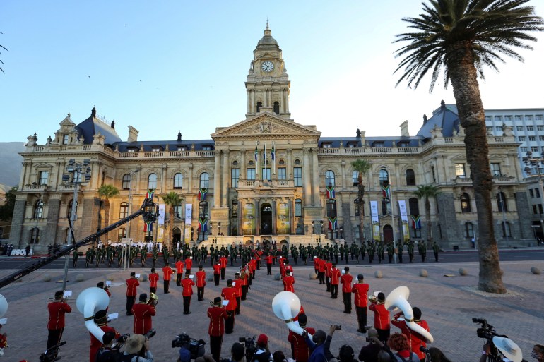 Members of the military band stand guard in front of the City Hall