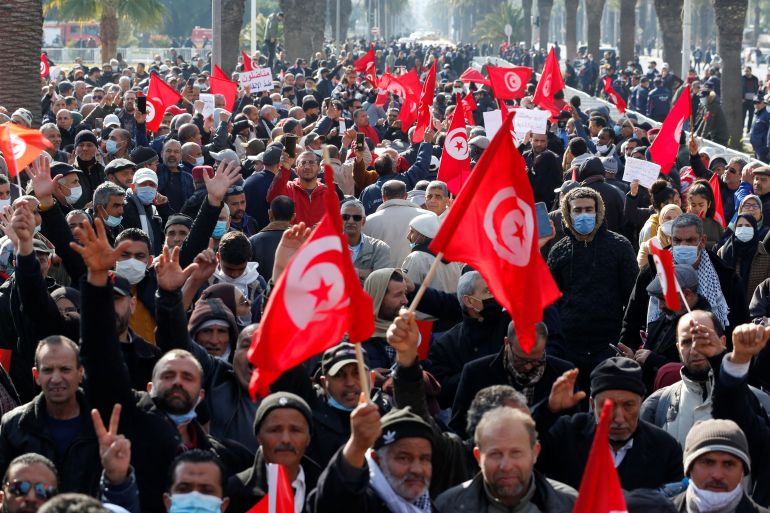 Demonstrators wave the Tunisian flags in the streets of the capital, Tunis.