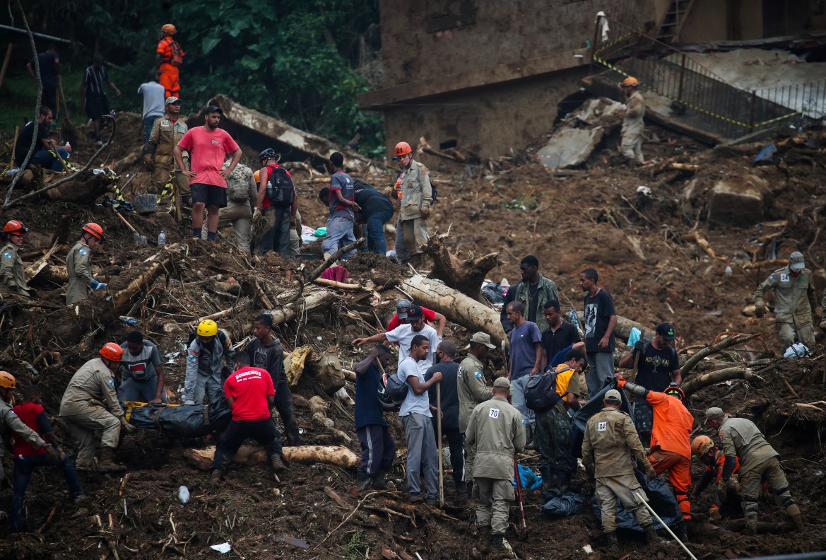 People carry bodies at a mudslide at Morro da Oficina after pouring rains in Petropolis