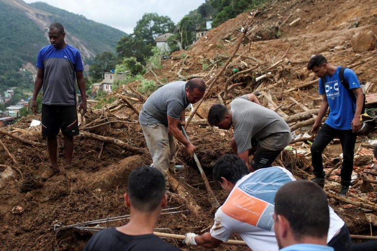 Marcelo Barbosa searches for the body of his wife at the site of a mudslide at Morro da Oficina after pouring rains in Petropolis, Brazil